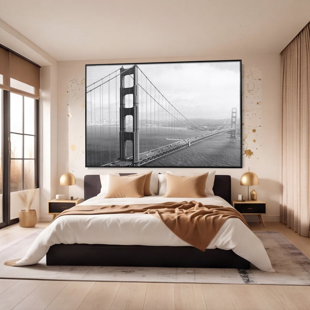 Tablou canvas cu fotografie alb-negru cu podul golden gate, in rama de aluminiu negru, pe perete intr-un dormitor